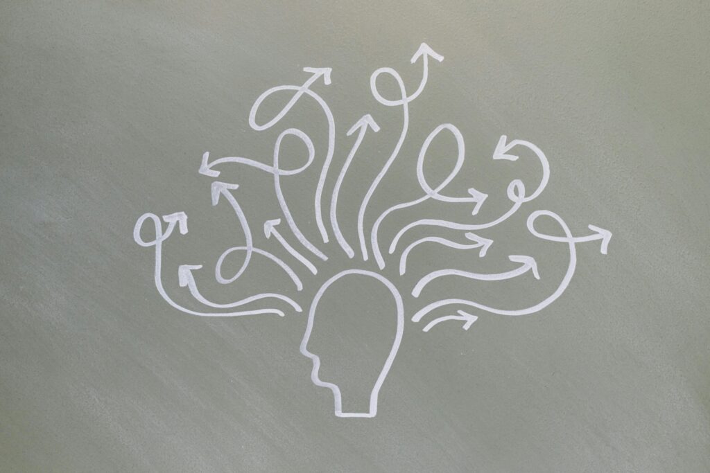 Conceptual chalk drawing illustrating mental health challenges with arrows representing thoughts.